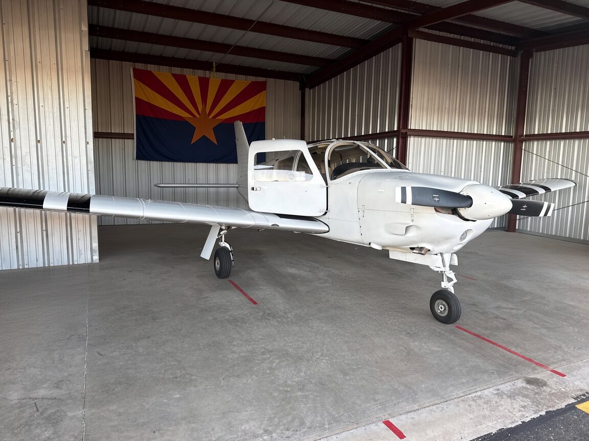The club's Piper Arrow III inside its hangar, with an Arizona state flag hanging on the back wall