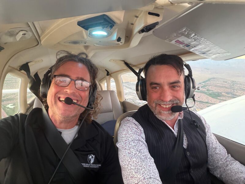 Two members in headsets in the cockpit during a flight