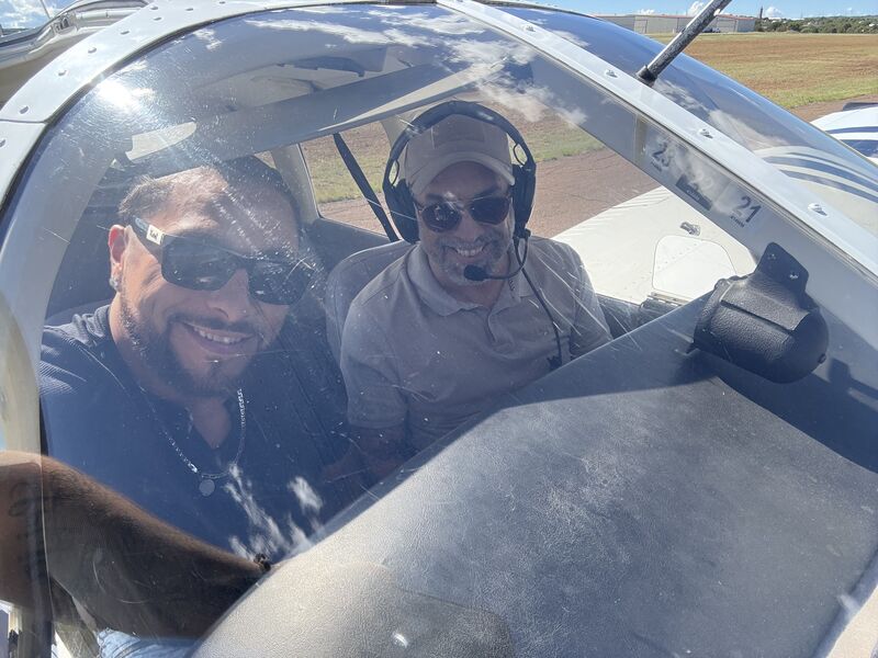 Two members seated in the cockpit before a flight
