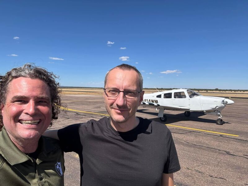 Two club members standing on the ramp in front of the Arrow