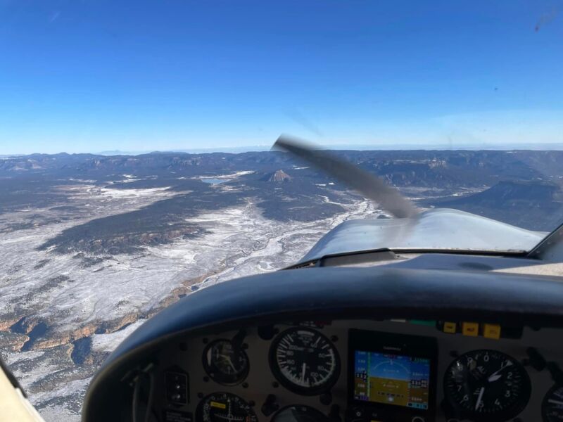 Looking out over snow-covered high country past the propeller