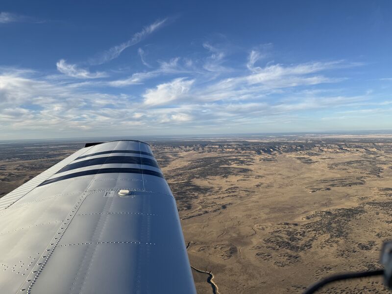 View along the wing over open desert on a clear morning